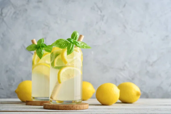 Limonáda Citrónem Bazalkou Studený Osvěžující Nápoj Brýlích Šedém Pozadí — Stock fotografie