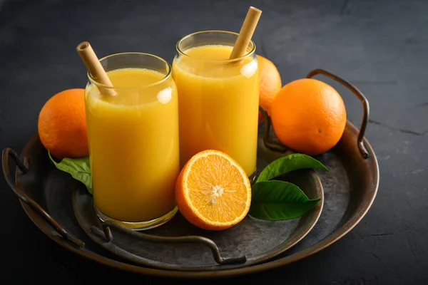 Twee Glazen Vers Sinaasappelsap Met Bamboe Drinkrietjes Een Lichte Houten — Stockfoto
