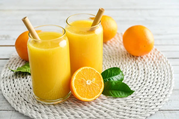 Twee Glazen Vers Sinaasappelsap Met Bamboe Drinkrietjes Een Lichte Houten — Stockfoto