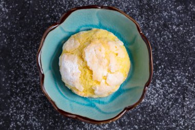 Tek ev yapımı limon Krinkıl tanımlama bilgisi ile pudra şekeri krema küçük mavi tabakta, üstten görünüm. 