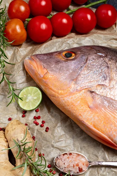 鲜生红鲷鱼 配香料 香草和蔬菜 用于在棕背纸上烹调 顶部视图 垂直组合 — 图库照片