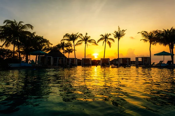 ヤシの木のシルエットと太陽の最後の線とスイミング プール サイドでの美しい熱帯の夕日 — ストック写真