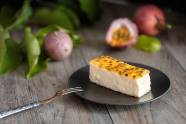 Tutku meyve peynir pasta dilimi karanlık plaka üzerinde