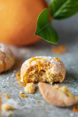 Gri arka plan, dikey kompozisyon üzerine pudra şekeri krema ile ev yapımı turuncu istasyonlu Krinkıl çerezlerin yakın çekim