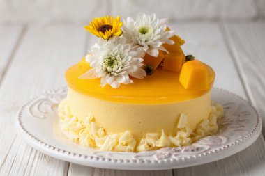 Mango cheesecake sarı jöle, Tepesi çiçek ve beyaz arka plan üzerinde taze mango adet yatay kompozisyonu ile