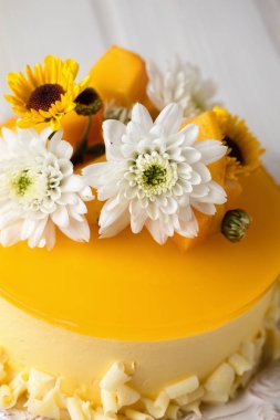 Mango cheesecake ile sarı jöle, Tepesi çiçek ve beyaz arka plan üzerinde taze mango adet dikey kompozisyon