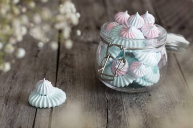 Pembe ve mavi ışık meringues cam kavanoz koyu arka plan üzerinde