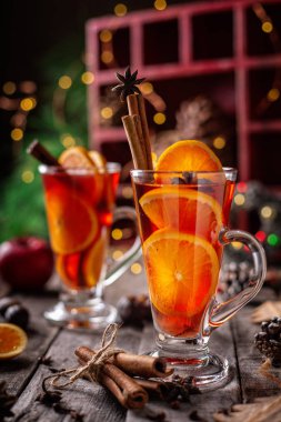Noel iki bardak kırmızı şarap ile baharat ve meyve ahşap rustik masa üzerinde mulled. Dikey kompozisyon 