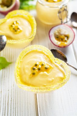 Cam ramekins tutku meyve mus beyaz ahşap arka planda, dikey kompozisyon ile iki kalp şeklinde 