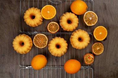 Küçük portakal bundt kek ile Kuru ve taze portakal soğutma kırışık, üstten görünüm, düz üzerinde yatıyordu 