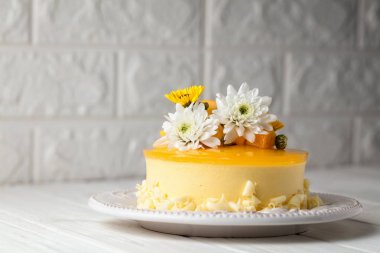 Çiçek ve gri arka plan, yatay kompozisyon üzerinde taze mango adet ile sırlı Mango cheesecake