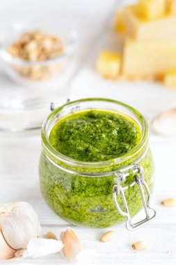 Ev yapımı fesleğen pesto sos ve taze madde beyaz arka plan üzerinde dikey kompozisyon 