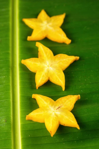 熟した黄色スター フルーツ ゴレンシのスター アップル Starfruit 緑のバナナの葉の垂直成分にスライス — ストック写真