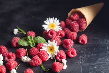 Dondurma koni koyu ahşap zemin üzerine alan çiçekli taze Deluxe ahududu.