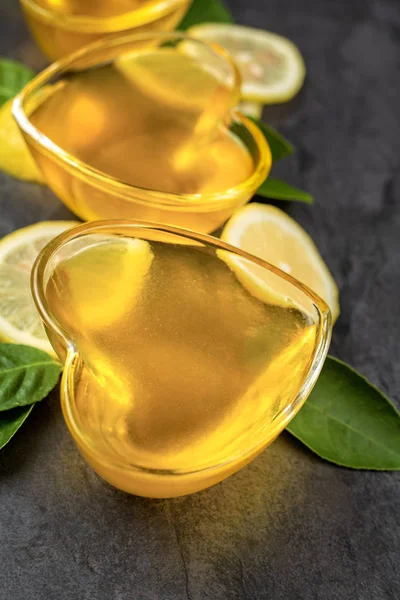 Yellow lemon jelly jello in heart shaped glass with cut lemon sl — Stock Photo, Image