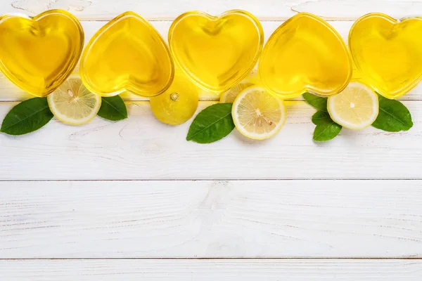 Yellow lemon jelly jello in heart shaped glass on white wooden b — 스톡 사진