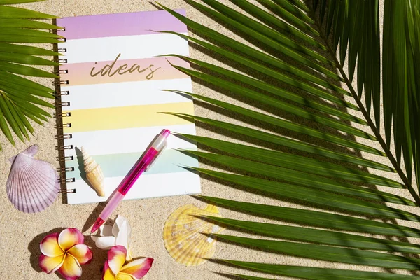 Carnet de voyage avec stylo rose sur sable avec feuille de palmier, s — Photo