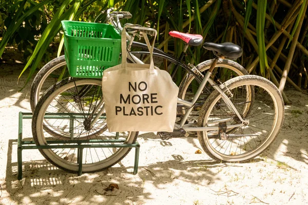 Tidak ada kantong eko plastik lagi di keranjang sepeda yang diparkir di hutan tropis berpasir — Stok Foto