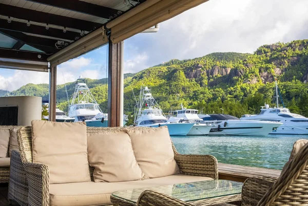 Kącik odpoczynku z widokiem na luksusowe jachty i łodzie w słoneczny letni dzień w przystani Eden Island, Mahe, Seszele — Zdjęcie stockowe