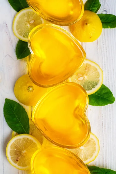 흰색 나무 배경에 하트 모양의 유리에 노란색 레몬 젤리 젤로, 상단보기 — 스톡 사진