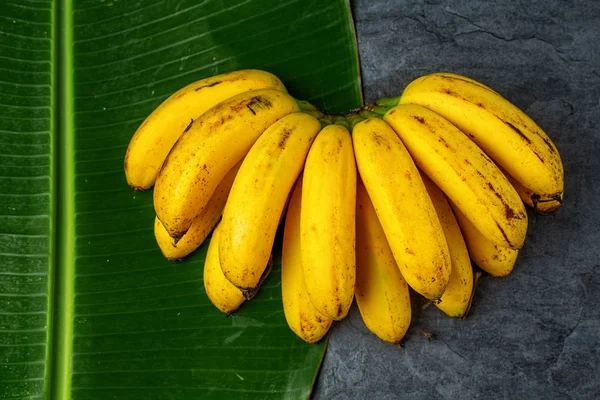 Mazzo di banane fresche su foglie di banana, vista dall'alto — Foto Stock