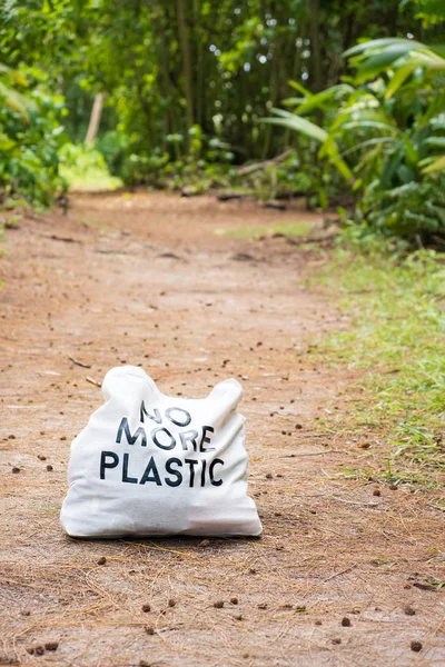 Eco bag NO LEBIH PLASTIC on Ground jalan pedesaan di tengah jalan hutan trropis — Stok Foto