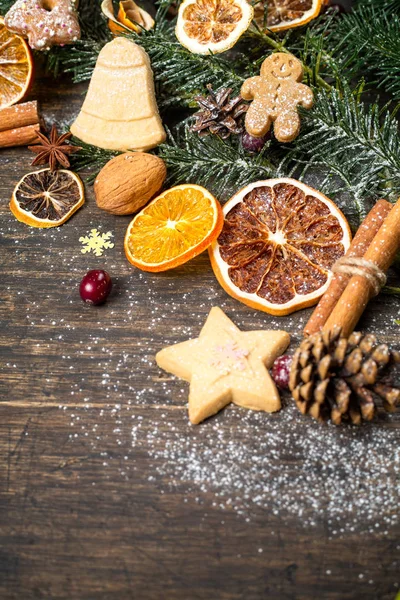 Świąteczne tło z gałęzi choinki, Dekoracje świąteczne, suche owoce, domowe ciasteczka i tradycyjne sezonowe przyprawy, kompozycja pionowa — Zdjęcie stockowe