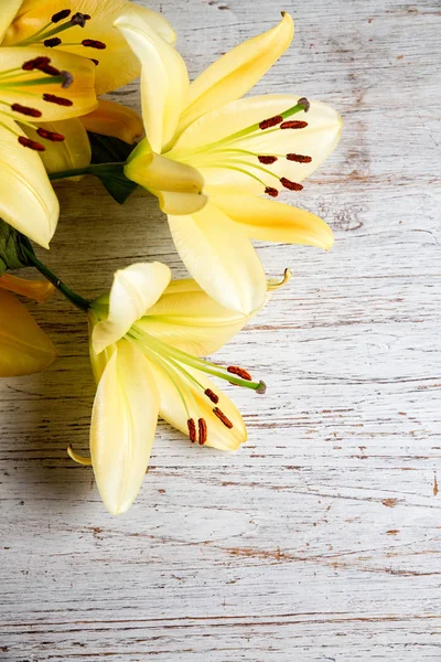 Żółta lilia na drewnianym tle, widok z góry, kompozycja pionowa — Zdjęcie stockowe