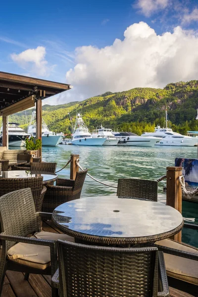 Mesa de jantar e cadeiras no pequeno restaurante decking por marina de Eden Island, Mahe, Seychelles, composição vertical — Fotografia de Stock