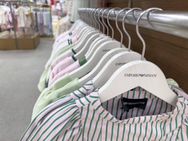 Singapur, Singapur - 3 Mayıs 2025 Pastel renkli Emporio Armani giysileri modern moda eğilimleri ve zarif tasarım unsurlarının sergilendiği bir perakende mağazasında sergileniyor