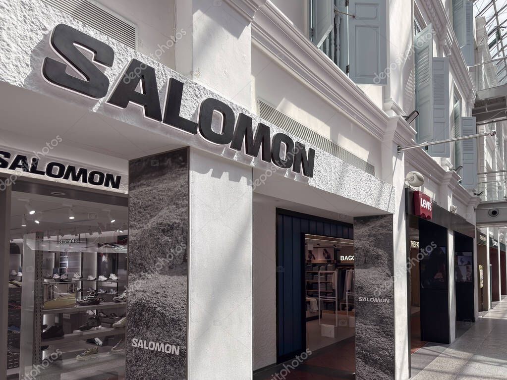 Singapore, Singapore - April 30, 2025: storefronts feature SALOMON and LEVIS signs. Clear visibility of products inside the store.