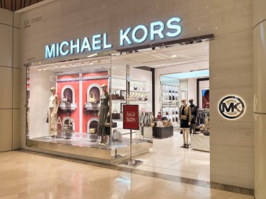 Kuala Lumpur, Malezya - 7 Temmuz 2025: MICHAEL KORS 'un vitrininde modaya uygun giyinmiş mankenler ve pencerelerde% 50' lik görünür bir satış tabelaları.