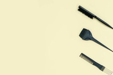 Sarı arka planda kuaför aksesuarları, üst manzara. Sarı arka planda düzenlenmiş profesyonel kuaför araçları koleksiyonu. 