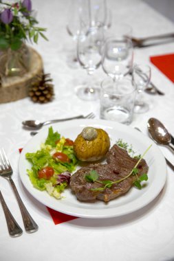 Dekore edilmiş bir Noel masa üzerinde bir tabakta et güzel hizmet bölümü