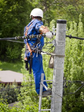 Elektrik tesisatçısının elektrik direğindeki işi.