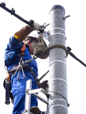 Elektrik tesisatçısının elektrik direğindeki işi.