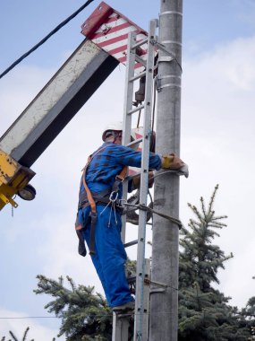 Elektrik tesisatçısının elektrik direğindeki işi.
