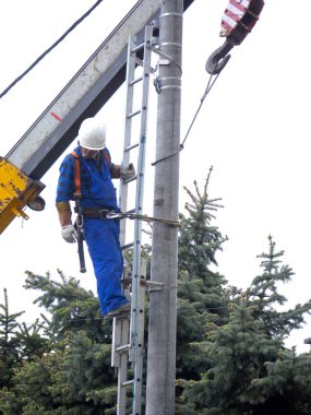 Elektrik tesisatçısının elektrik direğindeki işi.