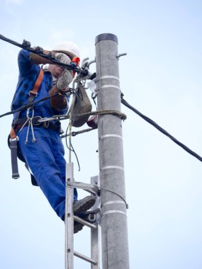 Elektrik tesisatçısının elektrik direğindeki işi.