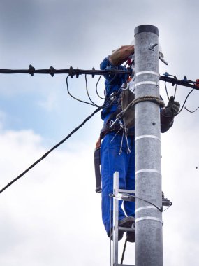 Elektrik tesisatçısının elektrik direğindeki işi.