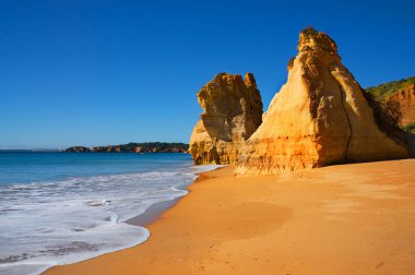 güzel Algarve kumsalda Praia da Rocha Portekiz, bulutsuz güneşli bir, hiçbir insan beach, tertemiz mavi gökyüzü, sarı kum ve parlak kayalar