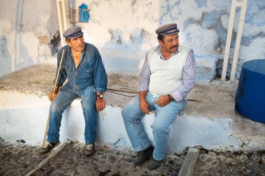 Santorini, Yunanistan - 19 Ekim, 2018: Fira, Santorini, turist ile eşek kuralları iki adam sheperds bir dinlenme yaşıyorsanız, işlerini zavallı hayvanların çok kötü niyetli