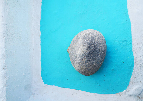 a stone on a ground in Santorini, Greece , typical Greek colors, simplicity of composition