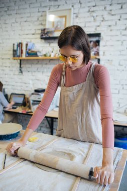 Potter's tekerlek üzerinde el işi, el ev ve satış için çeşitli öğeleri çamurdan mağazada yapacaklar ve sergisinde, seramik öğeleri el yapılır, güzel kız ürünleri çamurdan yapar
