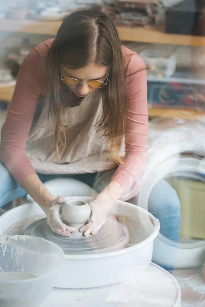 Handcrafted on a potter's wheel,Hands make clay from various items for home and sale in the store and at the exhibition, ceramic items are made in hand, beautiful girl makes products from clay