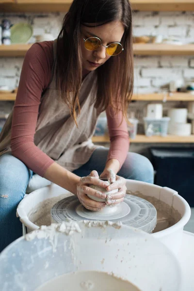 Handcrafted on a potter\'s wheel,Hands make clay from various items for home and sale in the store and at the exhibition, ceramic items are made in hand, beautiful girl makes products from clay