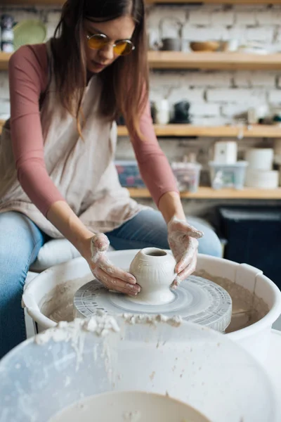 Handcrafted on a potter\'s wheel,Hands make clay from various items for home and sale in the store and at the exhibition, ceramic items are made in hand, beautiful girl makes products from clay