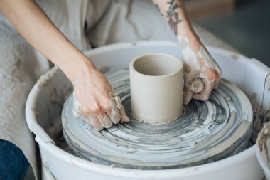 Potter's tekerlek üzerinde el işi, el ev ve satış için çeşitli öğeleri çamurdan mağazada yapacaklar ve sergisinde, seramik öğeleri el yapılır, kil kütük bir seramik tabak olur