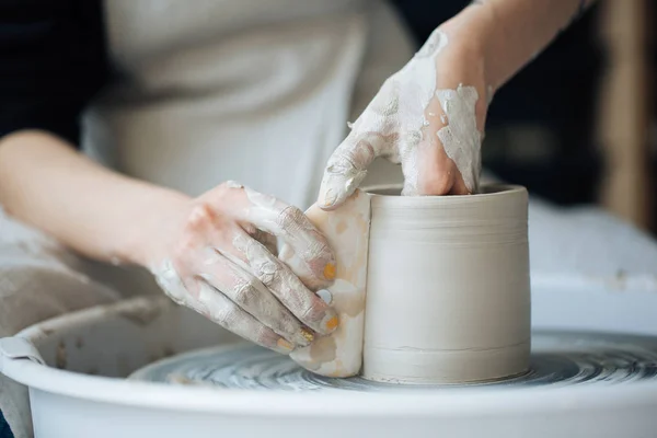 Handcrafted on a potter\'s wheel,Hands make clay from various items for home and sale in the store and at the exhibition, ceramic items are made in hand, the clay billet becomes a ceramic dish