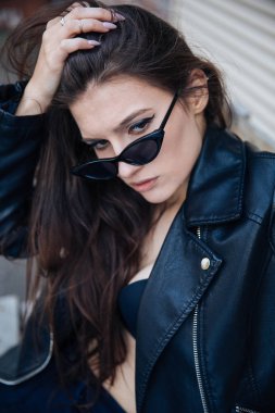 deri ceketli genç kız sigara içiyor, rock tarzı, arsız ve sevimli kız sokak poz tarzı, rock punk yaşam tarzı